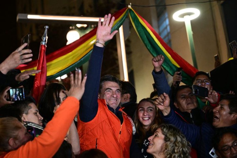 Rodrigo Paz, Bolivia's presidential candidate for the Christian Democratic Party (PDC), greets his supporters next to his wife Maria Elena Urquidi following the results of the presidential election in La Paz, Bolivia on August 17, 2025. Jorge "Tuto" Quiroga, a right-wing former president, and Rodrigo Paz, a senator from Bolivia's richest regions, will go head-to-head in the country's presidential runoff in October after leading the first round of voting on August 17, 2025. (Photo by Martin BERNETTI / AFP)