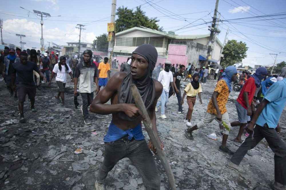 Un manifestante porta un pedazo de madera que finge es un rifle durante una protesta antigubernamental en Puerto Príncipe el 3 de octubre del 2022. (AP Photo/Odelyn Joseph)